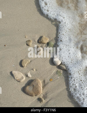 Steinen auf Sand und Bewegung verschwommen Welle Stockfoto