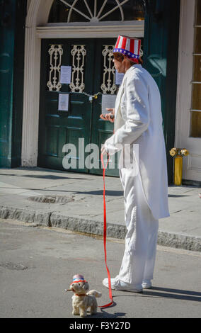 Eine Straße-Performance-Künstlerin im weißen Frack gekleidet und Hut mit ausgestopften Hund angeleint unterhält French Quarter, New Orleans, LA Stockfoto