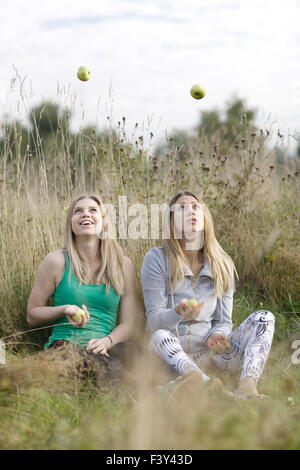 Zwei verspielte Mädchen jonglieren im freien Stockfoto