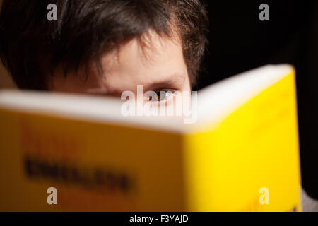 Junge, die Konzentration auf ein Buch zu lesen Stockfoto