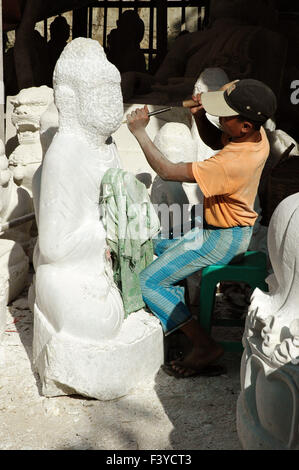 Sitzen Mann schnitzen einen Marmor Buddha Skulptur in einem Workshop in Mandalay, Myanmar Stockfoto