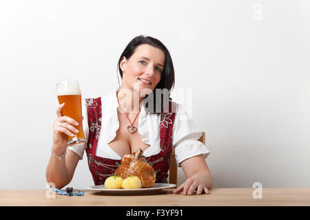 Bayerische Frau in ein Dirndl mit Schweinefleisch Stockfoto