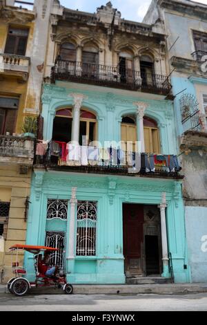 Fahrrad Taxi vor einem kolonialen Gebäude in einer ruhigen Wohnstraße in Havanna Kuba mit Wäsche auf dem Balkon aufgehängt Stockfoto