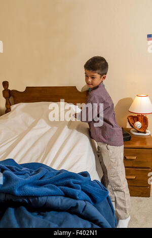 Ordentlich 7-10 jährige Olds Young Korean/American Boy sein Bett machen.   Herr © Myrleen Pearson Stockfoto