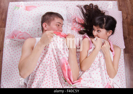Junges Paar erschrecken miteinander im Bett Stockfoto