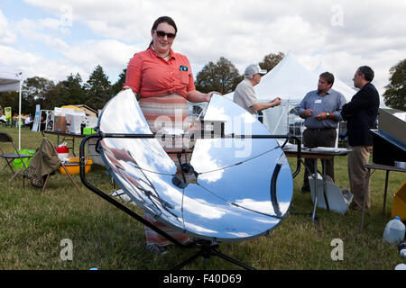 Frau zeigt einen parabolischen Solarkocher - USA Stockfoto