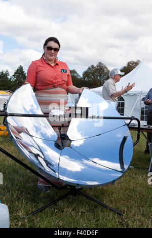 Frau zeigt einen parabolischen Solarkocher - USA Stockfoto