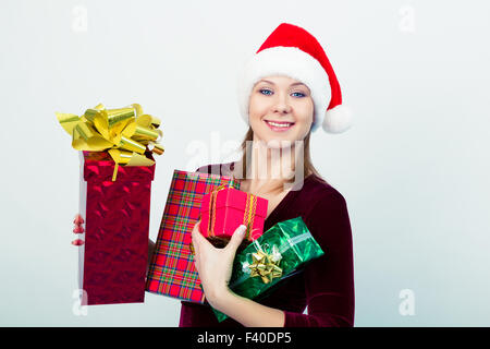 glückliches Mädchen in Nikolausmütze mit Geschenk-Boxen Stockfoto