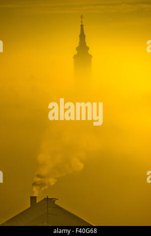 Golden Sunrise Kirchturm im Nebel Stockfoto