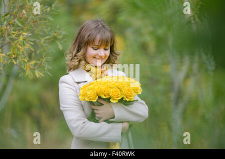 Glückliches Mädchen mit einem Bouquet von gelben Rosen Stockfoto