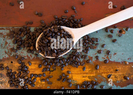 Kochlöffel mit Kaffeebohnen auf alten Holztisch vintage Stockfoto