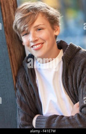 Glücklich lachende männliche junge blonde Teenager Kind außerhalb im Sommersonnenschein Stockfoto