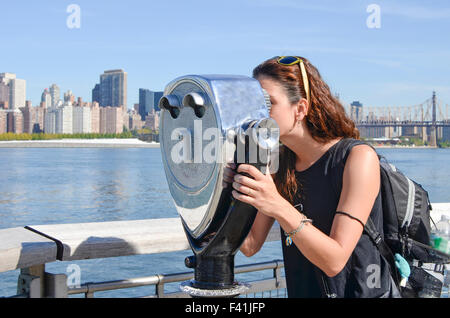 Mädchen auf der Suche durch öffentliche Fernglas im Manhattan View.  Blendenfleck aus Bincoulars an einem sonnigen Tag Stockfoto