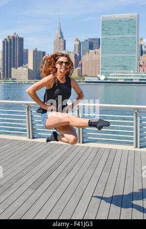 Mädchen darstellende Irish Dance "Birdie" springen gegen Manhattan view Stockfoto