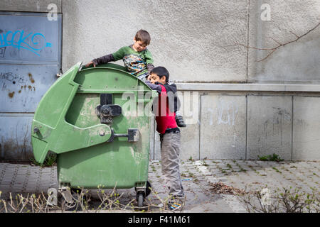 Zwei Zigeuner (Roma) jungen versucht, etwas zu essen oder etwas in nutzbare finden ein Müllcontainer Stockfoto