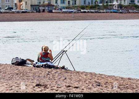 Mann und Frau Seefischerei off zurück Strand in Teignmouth, Devon, England am warmen Tag im September Stockfoto