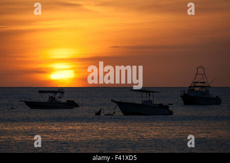 Sonnenuntergang über dem Meer in Beau Vallon Bay, Boote vertäut im Meer, die Sonne sinkt ins Meer, Insel Mahe, Seychellen Stockfoto