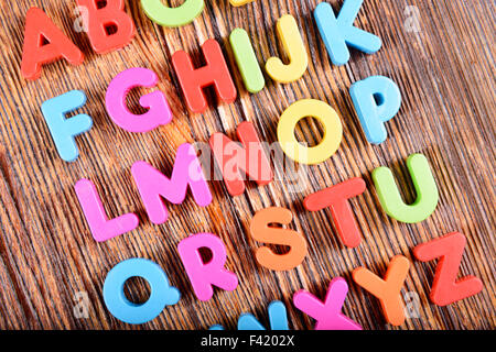 Zusammensetzung der bunten Kunststoff-Alphabet Buchstaben auf hölzernen Hintergrund Stockfoto