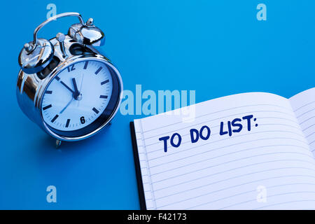 Wecker auf blaue Tabelle mit "to do" Liste Stockfoto