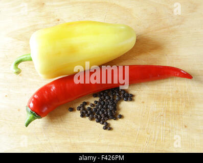 lange rote Paprika glänzende Küche Board mit getrockneten schwarzen Pfeffer und paprika Stockfoto