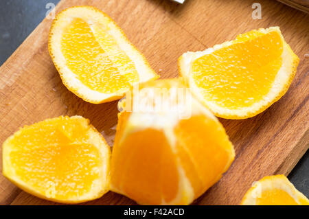 Schnitt auf ein Schneidebrett aus Holz saftige Reife Orange schälen Stockfoto