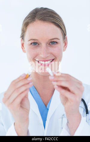 Arzt Holding gebrochen Zigarette Stockfoto