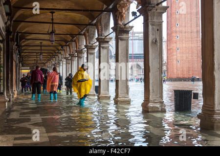 Markusplatz, Venedig, Italien. 14. Oktober 2015. Menschen Sie auf der Piazza San Marco tragen Regenponchos und Galoschen während der Acqua Alta oder "Hochwasser" die außergewöhnliche Flut-Gipfel, die in regelmäßigen Abständen, in der nördlichen Adria auftreten. Foto von: Richard Wayman Stockfoto