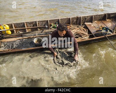 14. Oktober 2015 - Bangkok, Bangkok, Thailand - Schleusen ein Taucher Dinge, die er erzogen von der Unterseite des Flusses Chao Phraya in Bangkok, auf der Suche nach etwas, das er verkaufen kann. Taucher arbeiten in zwei-Mann-Teams auf kleinen Booten in den Fluss Chao Phraya. Eine Person bleibt im Boot, während die Taucher die Gewässersohle für alles durchforstet, die geborgen und weiterverkauft werden können. Die Taucher arbeiten in der Regel in Küstennähe, weil das Zentrum des Flusses ist ein beschäftigt kommerziellen Wasserstrasse mit Passagierschiffe und kommerzielle Fracht Lastkähne vorbei nach oben und unten des Fluss den ganzen Tag. Der Chao Phraya ist ein gefährlicher Fluss Tauchen. Ich Stockfoto