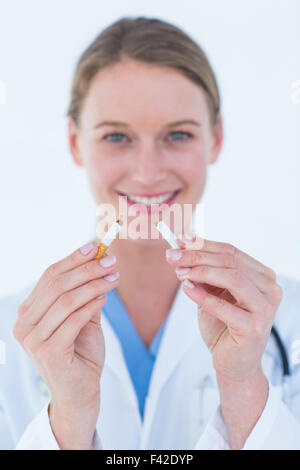 Arzt Holding gebrochen Zigarette Stockfoto