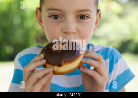 Niedliche kleine Mädchen essen Donut Stockfoto