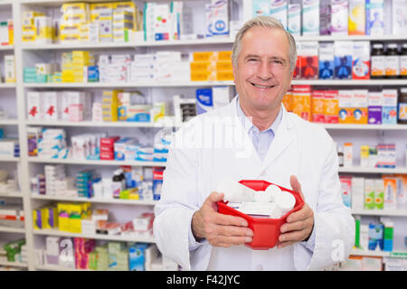 Leitender Apotheker hält Schüssel von Arzneimitteln Stockfoto