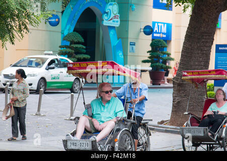 Touristen genießen ein Cyclo-Dreirad fahren durch die Straßen von Hanoi, der Hauptstadt von Vietnam, Asien Stockfoto