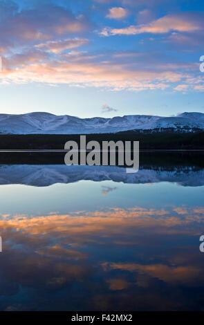 Winter Dämmerung Loch Morlich Cairngorm Plateau spiegelt sich in ruhigem Wasser, Schottisches Hochland, Schottland, Vereinigtes Königreich Stockfoto