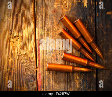 fünf Gewehr Patronen auf Holzoberfläche Stockfoto