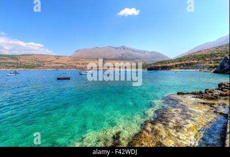 Die wunderschöne griechische Küste mit kristallklarem Wasser und viele Boote verankert in der Nähe von Diros Höhlen in Griechenland. Eine atemberaubende Landschaft Stockfoto