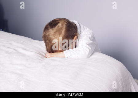 Kleiner Junge Kopf auf Bett ruhen Stockfoto