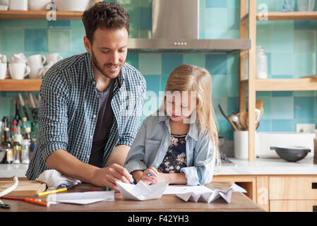 Vater und junge Tochter, die Zeichnung in der Küche Stockfoto