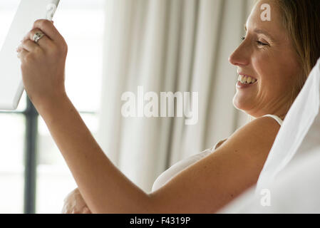 Schwangere Frau mit digital-Tablette für Videochats mit Freunden und Familie Stockfoto