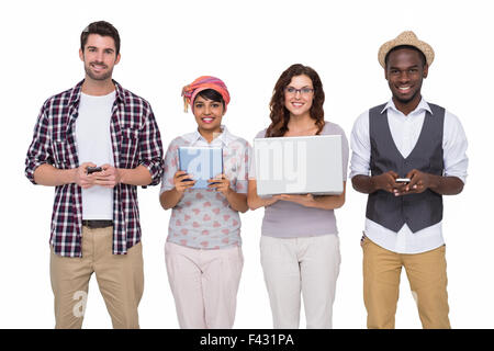 Lächelnde Mitarbeiter mit Technologie zu posieren Stockfoto