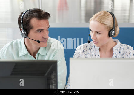 Kollegen über Kopfhörer während der Telefonkonferenz Stockfoto