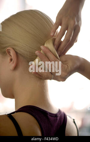 Friseur, die Vermittlung von Frau an den Haaren in einem Chignon, beschnitten Stockfoto