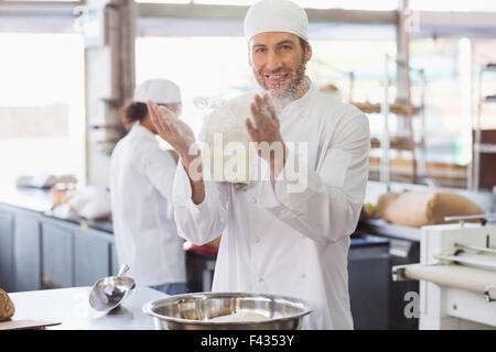 Baker, klatschte Mehl aus seinen Händen Stockfoto