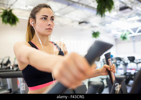 Fokussierte Frau auf dem Cross-trainer Stockfoto