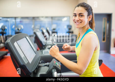 Lächelnde Frau laufen auf einem Laufband Stockfoto