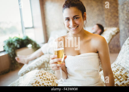 Lächelnde Frau hält ein Glas Champagner Stockfoto