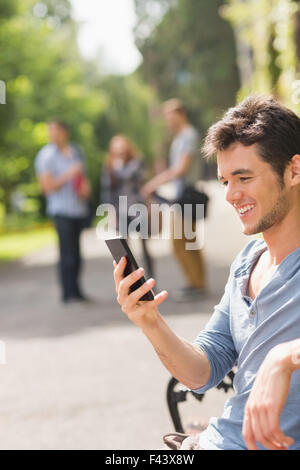 Hübsche Studentin SMS außerhalb Stockfoto