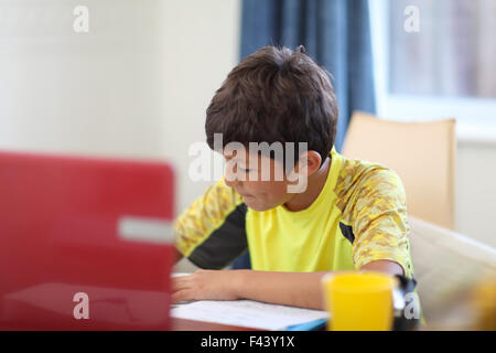 Kleiner Junge seine Hausaufgaben auf einem Computer - geringe Schärfentiefe Stockfoto