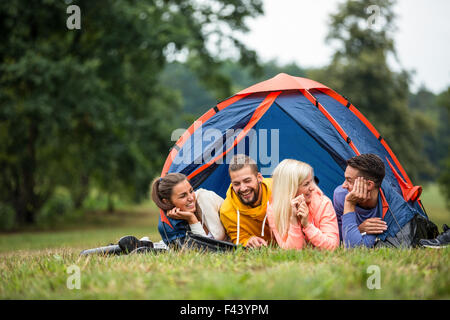 Glückliche Freunde liegen in ihrem Zelt Stockfoto