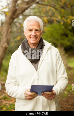 Senior Woman im Park mit tablet Stockfoto