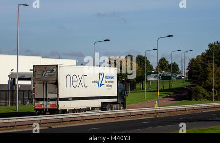 Schwenken 'Next' Mode Ladengeschäft artikuliert LKW Beschleunigung entlang der Kingsway West Schnellstraße in Dundee, Großbritannien Stockfoto